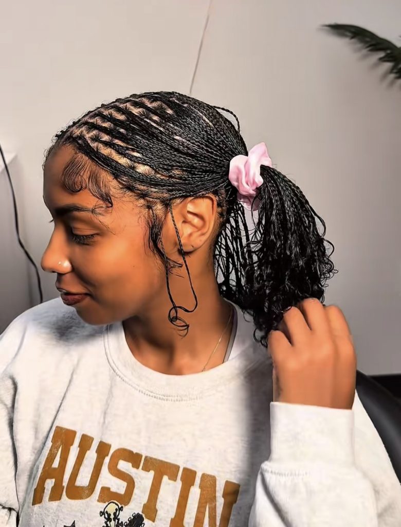 mini braids on natural hair styled in two messy ponytails with pink scrunchies