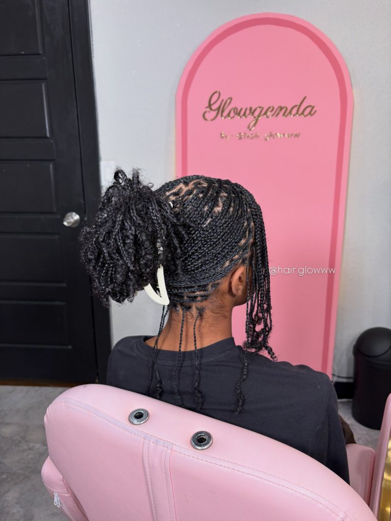 mini braids on natural hair with curly ends styled in a claw clip with bangs