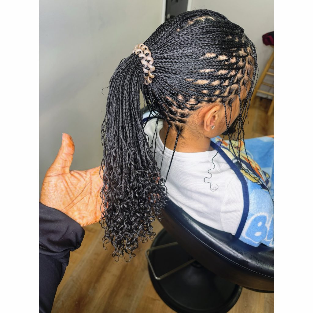 long natural hair mini braids with curly ends in a low easy ponytail