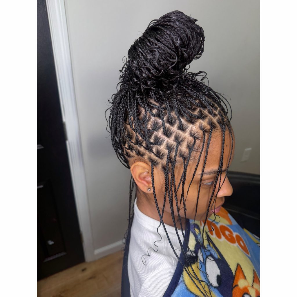long natural hair mini braids styled in a messy bun