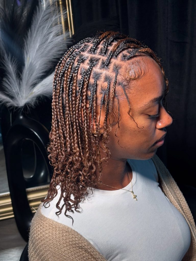 Natural hair mini braids with curly ends on chocolate brown hair styled in a side part